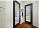 Hallway featuring wood floors, leading to outdoor views through glass-paneled doors at 18202 Abbey Ln, Lutz, FL 33548