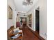 Hallway with hardwood floors leading to a living area, showcasing a bench and decorative accents at 18202 Abbey Ln, Lutz, FL 33548