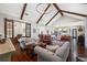 Open-concept living room featuring vaulted ceilings, exposed beams, hardwood floors, and stylish furniture at 18202 Abbey Ln, Lutz, FL 33548