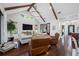 Bright living room with vaulted ceilings, exposed beams, hardwood floors, comfortable seating, and stylish lighting at 18202 Abbey Ln, Lutz, FL 33548