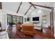 Spacious living room featuring vaulted ceilings with exposed beams, hardwood floors, and a sliding glass door at 18202 Abbey Ln, Lutz, FL 33548