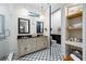 A view of the main bathroom featuring dual sinks, modern floors, and a toilet room at 18202 Abbey Ln, Lutz, FL 33548