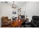 Spacious home office featuring a dark wood desk, chair, and view to a living area at 18202 Abbey Ln, Lutz, FL 33548