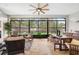 Screened-in patio with outdoor seating, ceiling fan, dining area, and views of the lush backyard and waterfront at 18202 Abbey Ln, Lutz, FL 33548