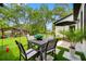 A stylish patio area with a dining table, seating, and lush green surroundings, perfect for outdoor gatherings at 18202 Abbey Ln, Lutz, FL 33548