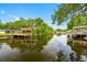 Beautiful waterfront view with a wooden dock and platform overlooking calm waters surrounded by lush greenery at 18202 Abbey Ln, Lutz, FL 33548
