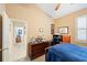 Comfortable bedroom with a ceiling fan, wooden bed, and view into the hall at 2043 Wrangler Dr, Brandon, FL 33511