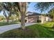 Charming single-Gathering home featuring a manicured lawn, mature trees, and a convenient two-car garage at 2043 Wrangler Dr, Brandon, FL 33511