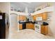 Well-lit kitchen boasts wood cabinets, black countertops, and stainless steel appliances at 2043 Wrangler Dr, Brandon, FL 33511