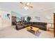 Inviting living room featuring a comfortable brown sectional sofa, ceiling fan, and bright interior at 2043 Wrangler Dr, Brandon, FL 33511