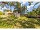 The expansive backyard features the home, a weathered shed, mature trees and a small boat on a trailer at 214 W Hanna Ave # A, Tampa, FL 33604