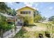 Charming two-story home with a sunny yellow exterior, featuring a quaint porch and simple landscaping at 214 W Hanna Ave # A, Tampa, FL 33604