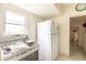 Cozy kitchen area showcasing a white refrigerator, stove, and easy-to-clean tile flooring at 214 W Hanna Ave # A, Tampa, FL 33604