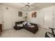 A simple living room featuring tile flooring, a ceiling fan, and a comfortable brown couch at 214 W Hanna Ave # A, Tampa, FL 33604