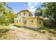 Back of the home featuring a weathered yellow exterior, small windows, and an adjacent lattice-skirted addition at 214 W Hanna Ave # A, Tampa, FL 33604