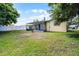 Large backyard featuring a screened patio, white fencing, and lush green grass at 2481 12Th Sw Ave, Largo, FL 33770