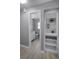 Bright hallway view to a bathroom with white cabinets and a built in shelved nook for storage at 2481 12Th Sw Ave, Largo, FL 33770