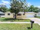 Charming yellow single-story home with a well-manicured lawn and mature tree in a sunny neighborhood at 2481 12Th Sw Ave, Largo, FL 33770
