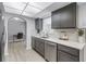 Spacious kitchen showcasing stainless steel appliances, sleek grey cabinets, and a seamless transition to the dining area at 2481 12Th Sw Ave, Largo, FL 33770
