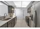 Modern kitchen featuring stainless steel appliances, grey cabinetry, subway tile backsplash, and ample countertop space at 2481 12Th Sw Ave, Largo, FL 33770