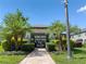 Community amenity center with gated entrance, lush landscaping, and paver walkway at 2487 Golden Pasture Cir, Clearwater, FL 33764