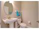 Cozy half bathroom with a pedestal sink, toilet, and neutral wall paint at 2487 Golden Pasture Cir, Clearwater, FL 33764