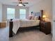 Bedroom with bed, white bedding, two windows, and a dark wood nightstand at 2487 Golden Pasture Cir, Clearwater, FL 33764