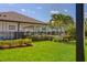 Community pool area surrounded by green grass and palm trees, seen through screen at 2487 Golden Pasture Cir, Clearwater, FL 33764