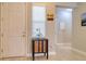 Welcoming foyer features light tile flooring, decorative cabinet, artwork and a view into the home's living spaces at 2487 Golden Pasture Cir, Clearwater, FL 33764