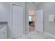 Hallway leads to a bedroom with a chandelier, window, and blue bedding at 2487 Golden Pasture Cir, Clearwater, FL 33764