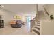 Open-concept living room with tile flooring, a plush couch, and stairs leading to the upper level at 2487 Golden Pasture Cir, Clearwater, FL 33764