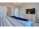 Main bedroom with TV and lots of light with blue duvet and decorative furniture at 2487 Golden Pasture Cir, Clearwater, FL 33764