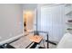 Office space with glass desk, black chair, and doorway leading to a laundry room at 2487 Golden Pasture Cir, Clearwater, FL 33764