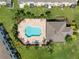 Aerial view of the community pool and amenity center surrounded by green lawns and palm trees at 2487 Golden Pasture Cir, Clearwater, FL 33764