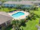 Aerial view of community pool surrounded by palm trees, lounge chairs, and landscaped grounds at 2487 Golden Pasture Cir, Clearwater, FL 33764