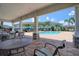 View of community pool from shade, highlighting seating and tropical landscaping at 2487 Golden Pasture Cir, Clearwater, FL 33764