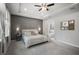 A spacious bedroom with a tray ceiling and gray accent wall, carpet flooring, and ensuite bathroom at 2513 Knight Island Dr, Brandon, FL 33511
