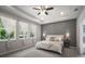 Bright bedroom featuring a gray accent wall, tray ceilings, and abundant natural light from large windows at 2513 Knight Island Dr, Brandon, FL 33511