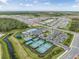 An aerial view of the community amenities including pool, tennis courts, playground, clubhouse, and parking at 3197 Acacia Bay Ave, Wesley Chapel, FL 33543