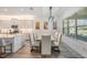 Elegant dining area features a marble table, upholstered chairs, and modern lighting, adjacent to a well-equipped kitchen at 3197 Acacia Bay Ave, Wesley Chapel, FL 33543