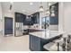 Modern kitchen showcasing sleek, dark cabinets, island with marble counters, and stainless steel appliances at 3197 Acacia Bay Ave, Wesley Chapel, FL 33543