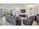 Comfortable living room with stylish decor, built-in shelving, a sectional sofa, and access to an outdoor patio at 3197 Acacia Bay Ave, Wesley Chapel, FL 33543
