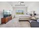 Bright main bedroom featuring tray ceiling, carpet, and a large window for natural light at 3197 Acacia Bay Ave, Wesley Chapel, FL 33543