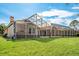 A backyard with a large, screened-in patio and green lawn extending to the rear of the home at 3337 Crescent Oaks Blvd, Tarpon Springs, FL 34688