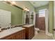 Bathroom featuring dual sinks, a large mirror and shower with decorative tile at 3337 Crescent Oaks Blvd, Tarpon Springs, FL 34688