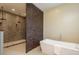 Modern bathroom featuring a soaking tub, tiled shower with dual heads and 3D accent wall at 3337 Crescent Oaks Blvd, Tarpon Springs, FL 34688