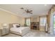 Bright bedroom featuring a ceiling fan, tiled fireplace, and neutral color palette at 3337 Crescent Oaks Blvd, Tarpon Springs, FL 34688