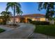 Beautiful home exterior with mature palms, decorative rock beds and a curved driveway at 3337 Crescent Oaks Blvd, Tarpon Springs, FL 34688