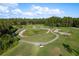 Aerial image of a golf course featuring manicured greens, sand traps, and ponds at 3337 Crescent Oaks Blvd, Tarpon Springs, FL 34688