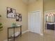 Hallway with closet, view to the bathroom, artwork, and a small decorative table at 3337 Crescent Oaks Blvd, Tarpon Springs, FL 34688